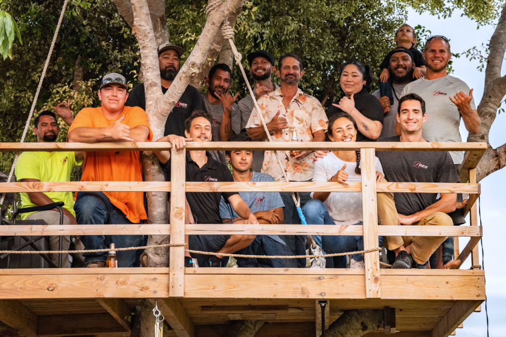 A group of people standing on top of a tree house.