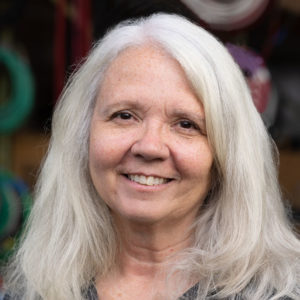 A woman with long white hair smiling.