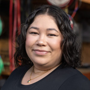 A woman in a black shirt is smiling.