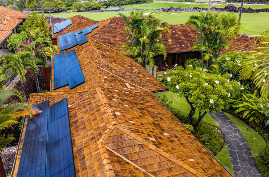 An aerial view of a house with solar panels on the roof.