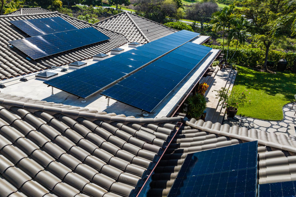 An aerial view of solar panels on a roof.