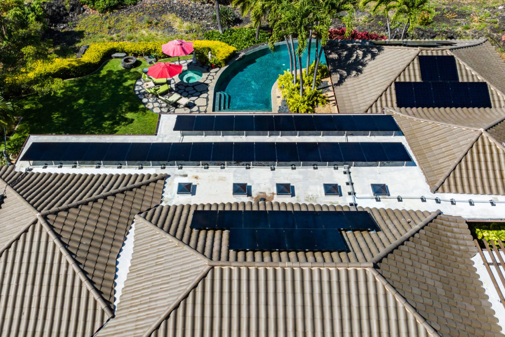 An aerial view of a home with solar panels on the roof.