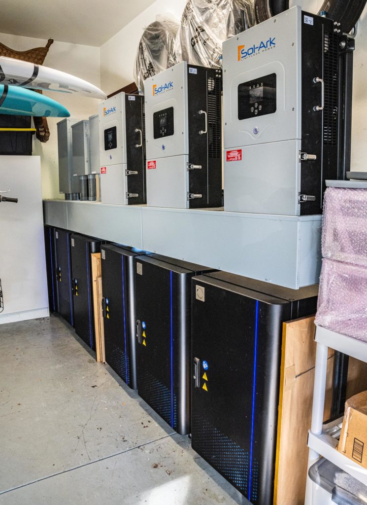 A garage with multiple Blue Ion HI batteries and Sol-Ark inverters.