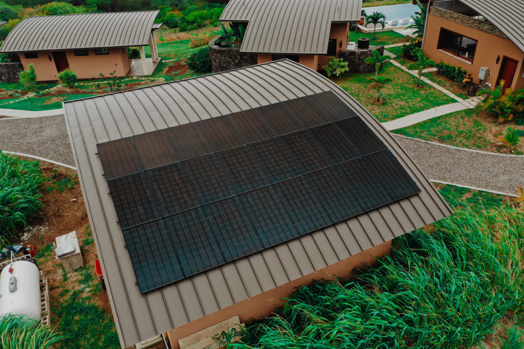 An aerial view of a house with solar panels on the roof.