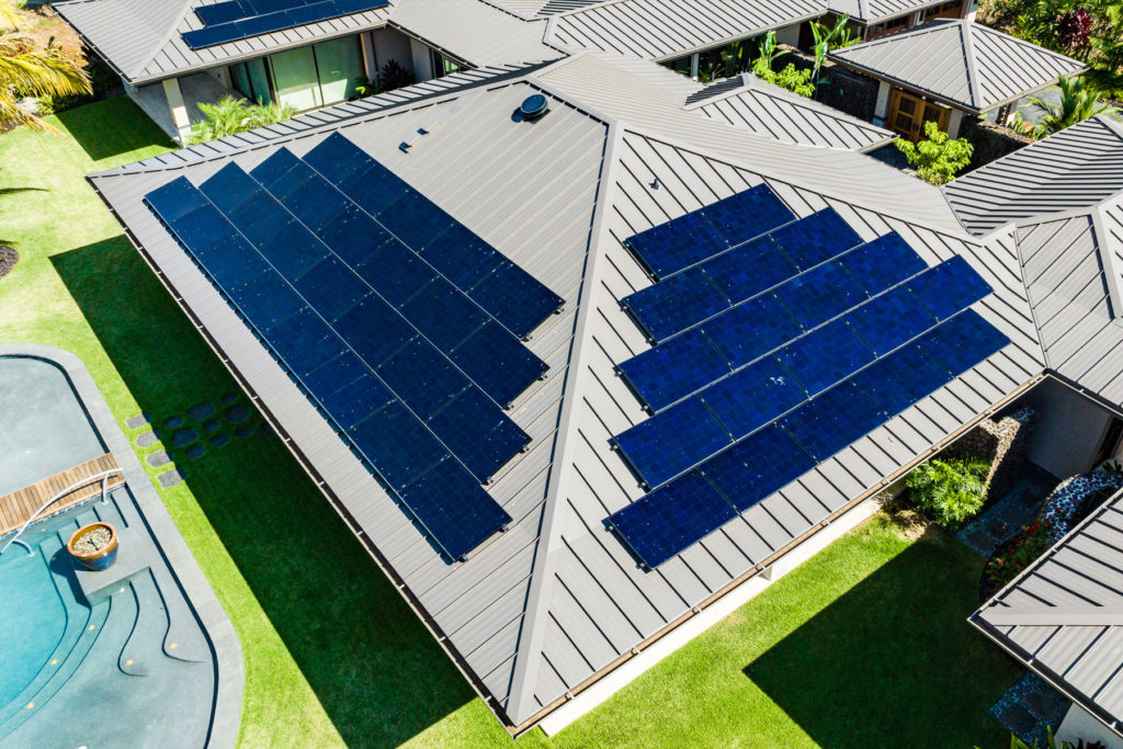 An aerial view of a house with solar panels on the roof.