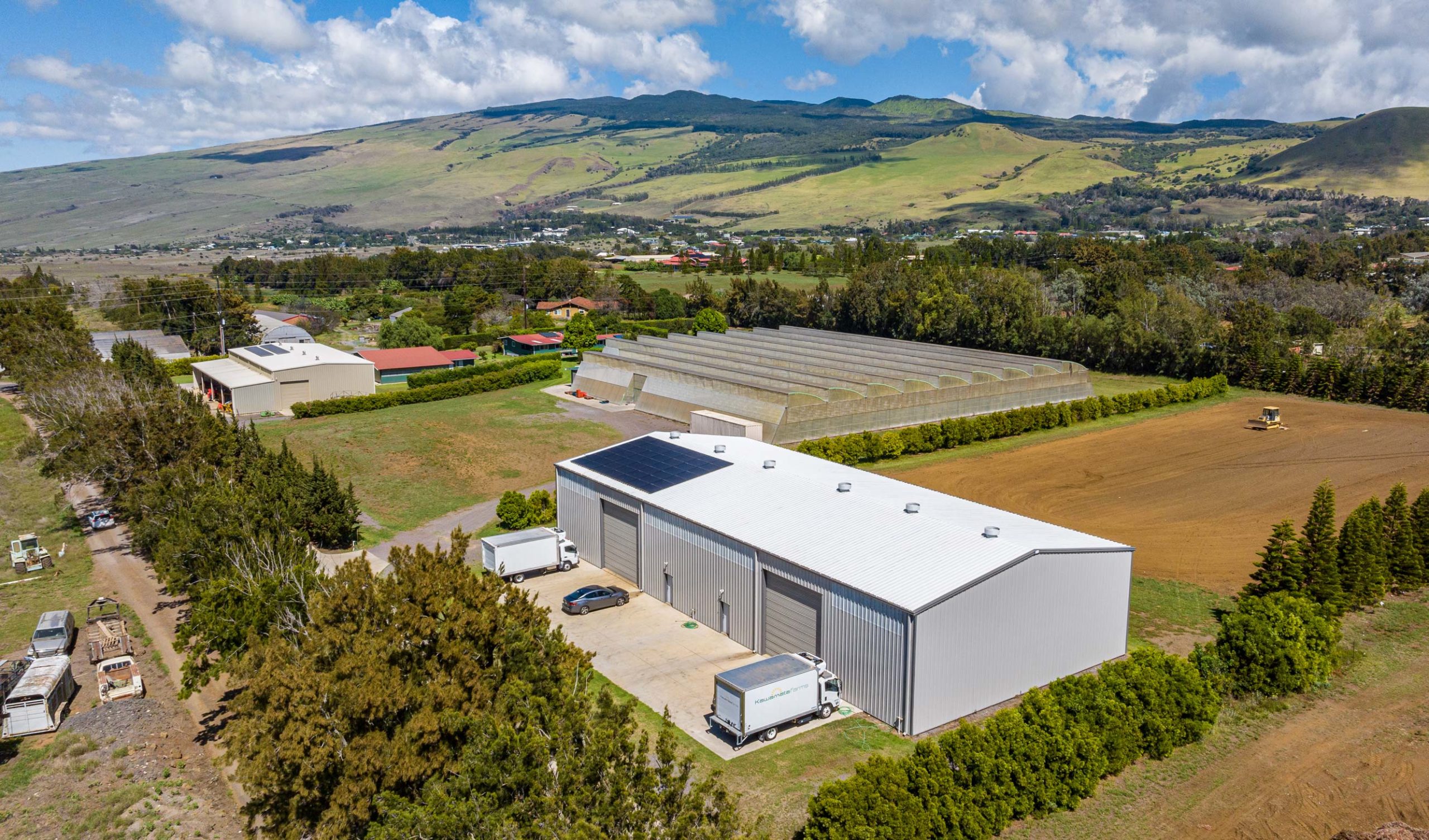An aerial view of an agriculture building with rooftop solar panels.