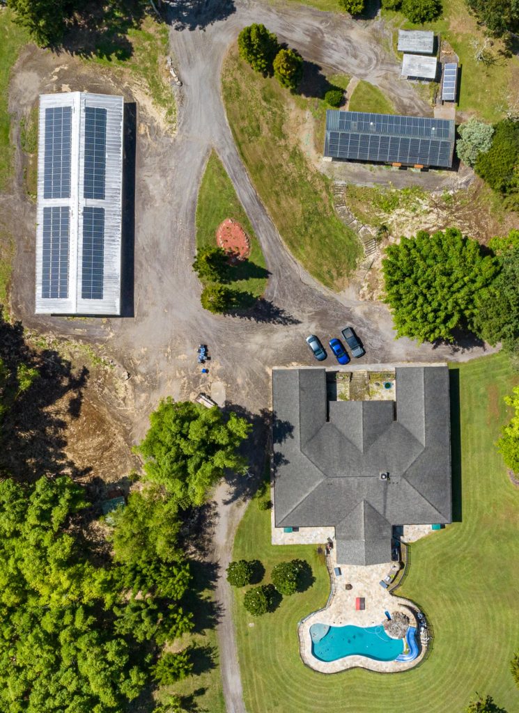 An aerial view of a house with solar panels and a pool.