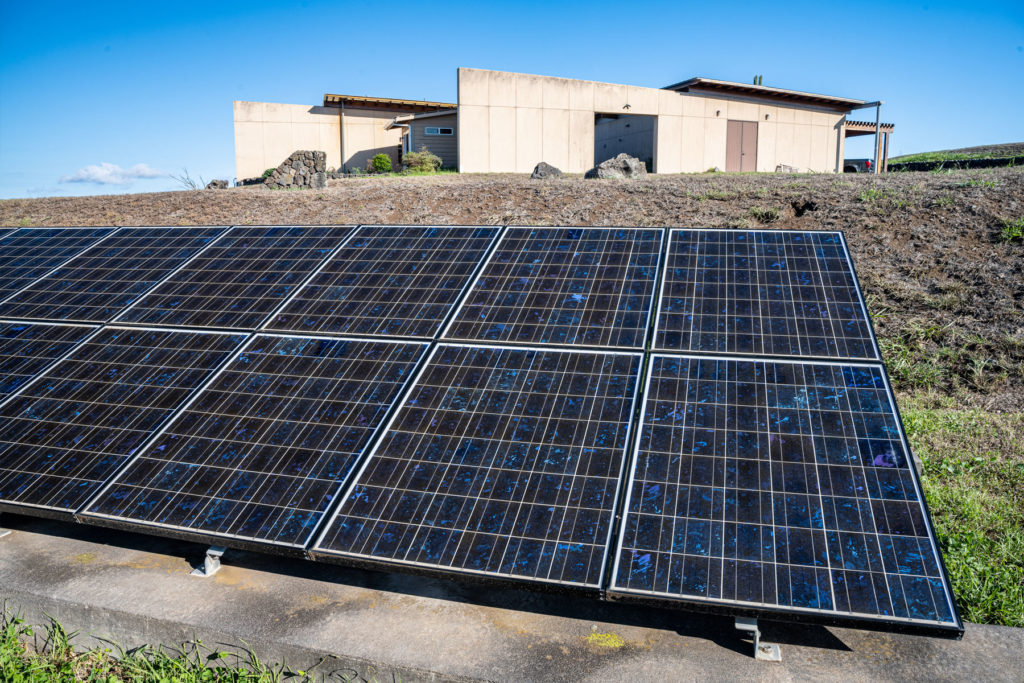 Ground mounted solar panels in front of a house.